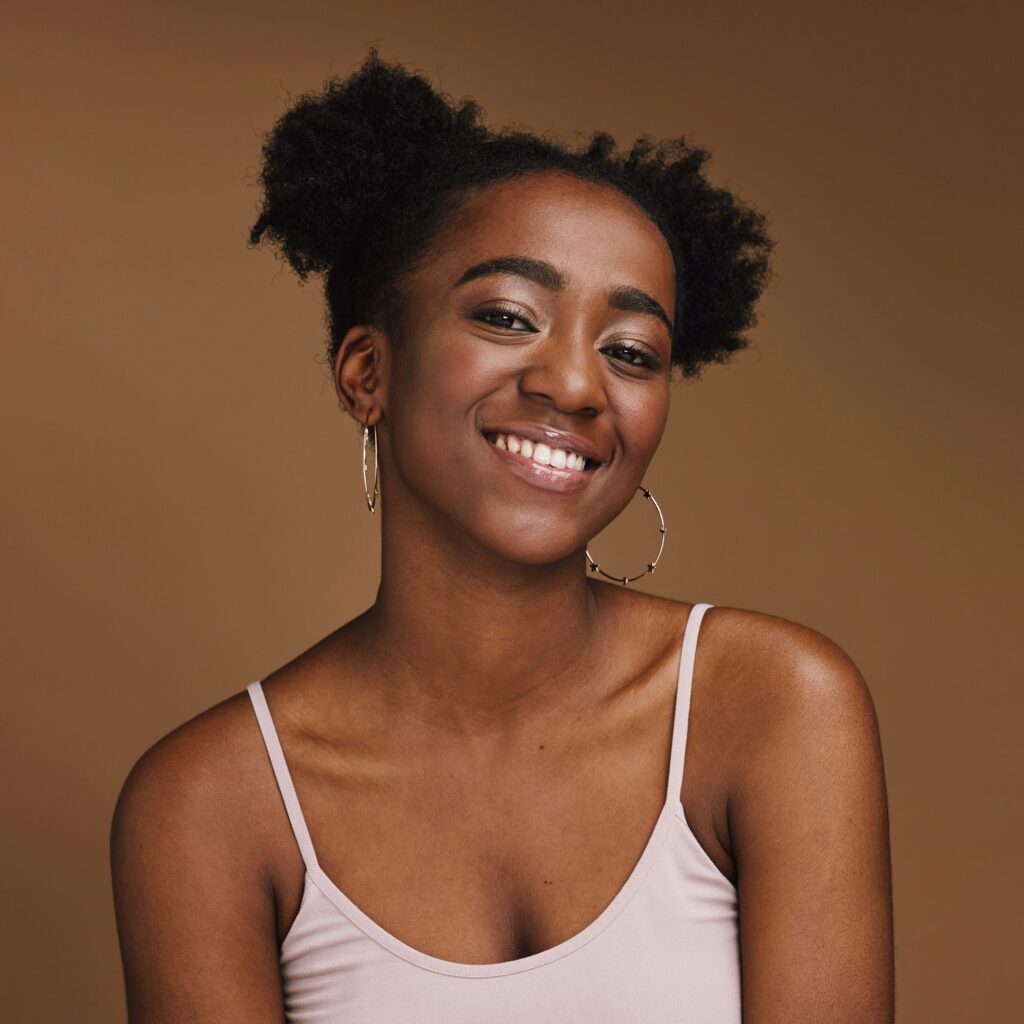 Black woman, smile and student portrait of a gen z person with makeup and jewelry in a studio. Isol